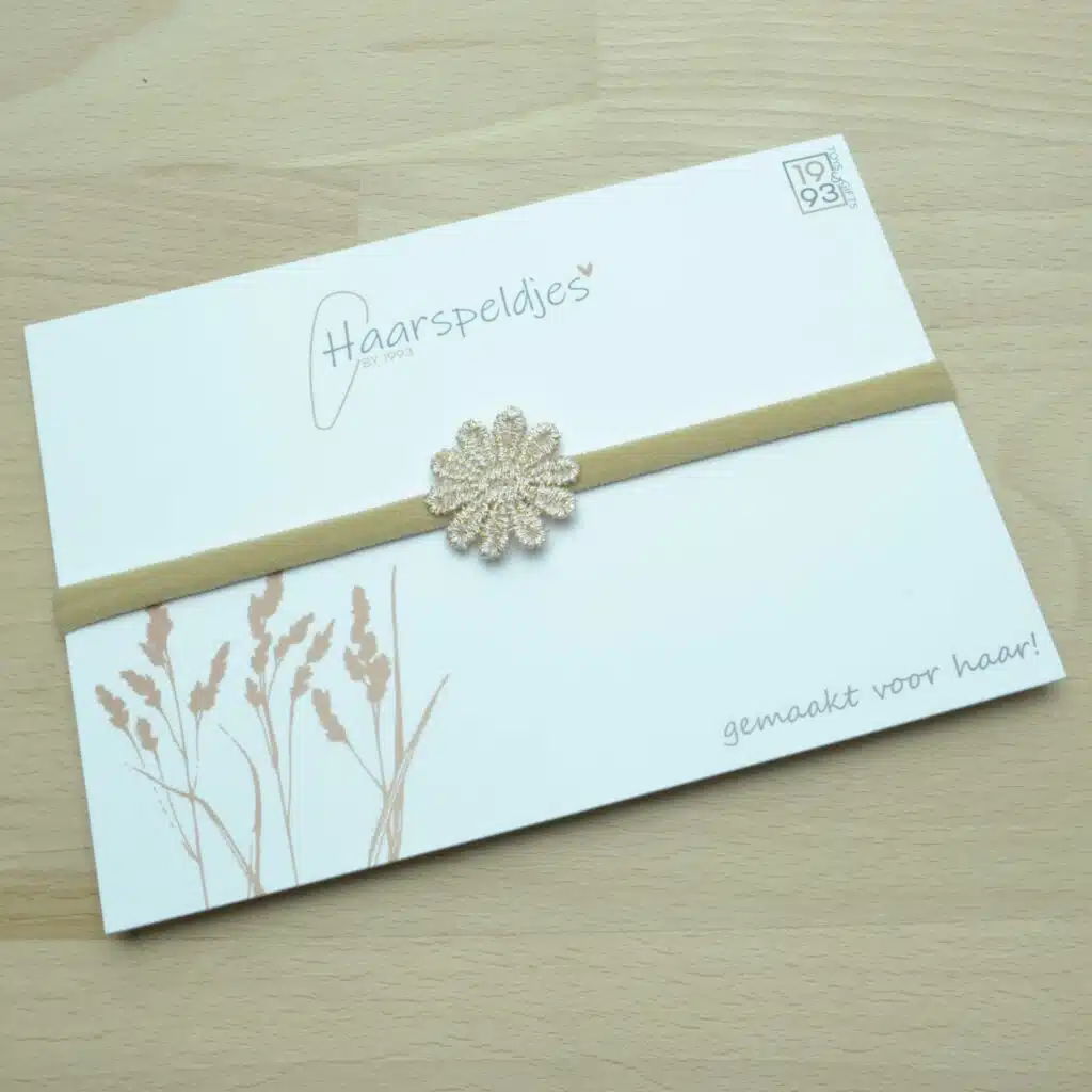 Nylon haarbandje met een bruin gouden bloemetje. gouddraad