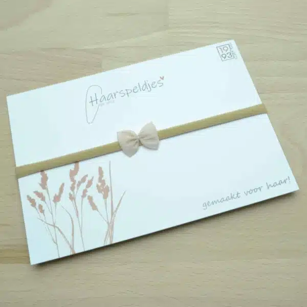 Zachtroze/nuderoze strikje op nylon haarbandje. Zacht haarbandje voor baby's.