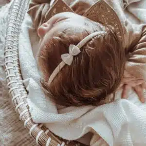 Zachtroze/nuderoze strikje op nylon haarbandje. Zacht haarbandje voor baby's.