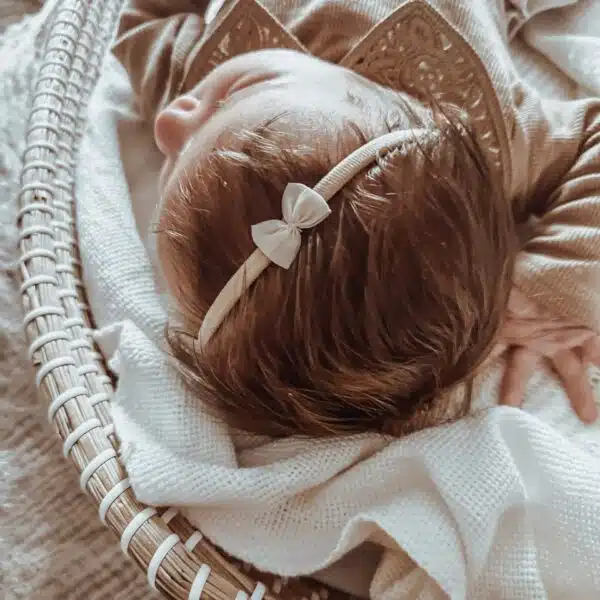 Zachtroze/nuderoze strikje op nylon haarbandje. Zacht haarbandje voor baby's.