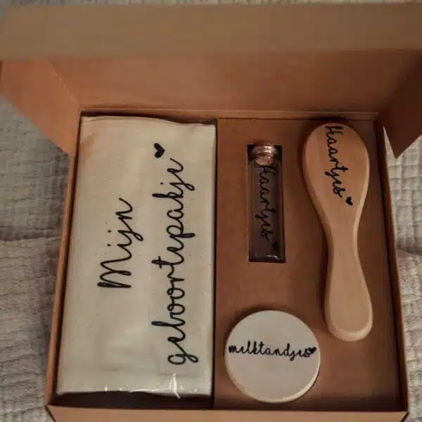 Open verpakking de babybox by 1993. kraamcadeau. geboortepakje bewaarzakje, tandendoosje, haarborstel en reageerbuisje